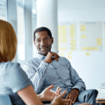 Businessman attentively listening to coworker speak.