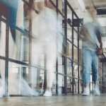 People walking down a hall in an office.